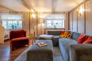 sala de estar con sofá azul y silla roja en Alkoven, en Braderup