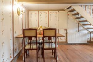 Un comedor con mesa y sillas y una escalera. en Alkoven, en Braderup