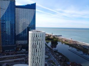 an aerial view of a tall building next to the ocean at Aphrodite Apartments Batumi in Batumi