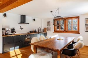 a kitchen with a wooden table and chairs at Chalet Flocke Sternschnuppe in Sankt Anton am Arlberg +30 photos