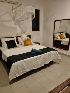 - une chambre avec un grand lit et un miroir dans l'établissement Maria Villa, à Negombo