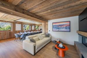 un salon avec un canapé blanc et une cheminée dans l'établissement Chalet Carriaz Meribel Village 14pers à 5min à pieds des pistes et commerces, à Les Allues