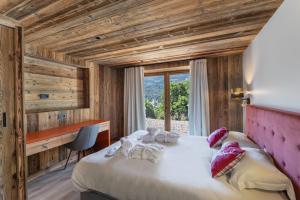 a bedroom with a large bed and a window at Chalet Carriaz Meribel Village 14pers à 5min à pieds des pistes et commerces in Les Allues
