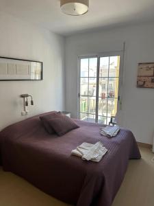 une chambre avec un lit avec deux serviettes dessus dans l'établissement Trevlig lägenhet i City Nerja, à Nerja