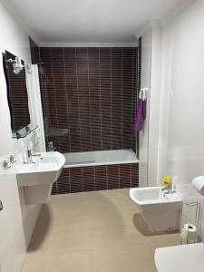 une salle de bain avec une baignoire, un lavabo et des toilettes dans l'établissement Trevlig lägenhet i City Nerja, à Nerja 7 autres photos