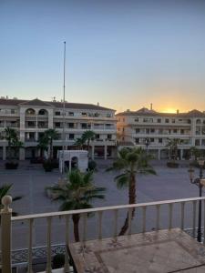 - une vue sur un parking avec des palmiers et des bâtiments dans l'établissement Trevlig lägenhet i City Nerja, à Nerja