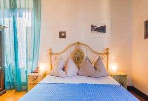 Un dormitorio con una cama azul y blanca con almohadas en Locanda di CasalMustia, en Castelmuzio