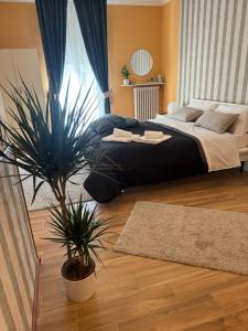 アヴェッツァーノにあるCasina Dei Marsiの大型ベッドと鉢植えの植物が備わるベッドルーム1室