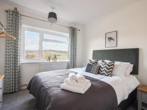 a bedroom with a bed with two towels on it at Hook Farm Cottage in Lyme Regis