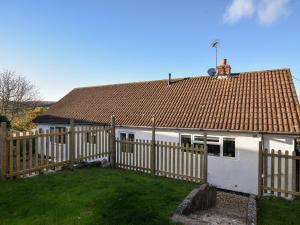 a wooden fence in front of a white house at Hook Farm Cottage in Lyme Regis