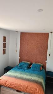 um quarto com uma cama com um edredão laranja e azul em Gîte du Riez em Jujurieux