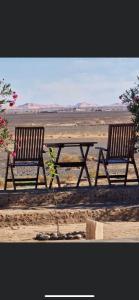dwie ławki i stół piknikowy na pustyni w obiekcie Maison Boutchrafine w mieście Arfud