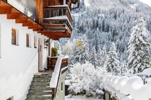 a snowy stairway to a building with snow covered trees at Chalet Flocke Appart Murmeltier in Sankt Anton am Arlberg