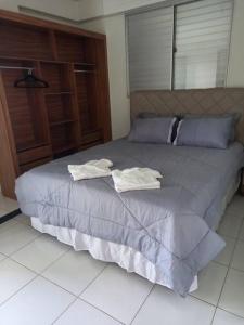 - un lit avec 2 serviettes assises au-dessus dans l'établissement Apartamento Todos os Santos próximo da Unimontes, à Montes Claros