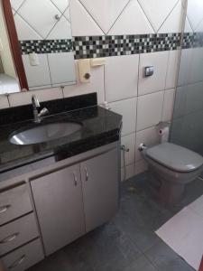 La salle de bains est pourvue d'un lavabo et de toilettes. dans l'établissement Apartamento Todos os Santos próximo da Unimontes, à Montes Claros