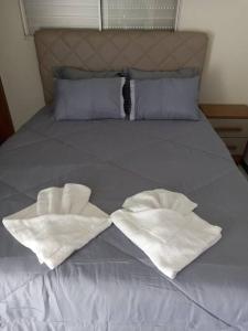- un lit avec 2 serviettes blanches dans l'établissement Apartamento Todos os Santos próximo da Unimontes, à Montes Claros
