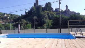 an empty swimming pool with a blue at Appartamenti - Here&Now in front of The Castle in Tresana