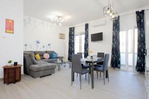 a living room with a couch and a table and chairs at Tranquillità Centrale - Vicino Spiaggia e Aeroporto in Fiumicino