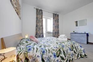 a bedroom with a bed with a floral bedspread at Tranquillità Centrale - Vicino Spiaggia e Aeroporto in Fiumicino