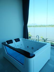 a bath tub in a room with a large window at Pool Villa Rimkhong Nakhorn Panom 