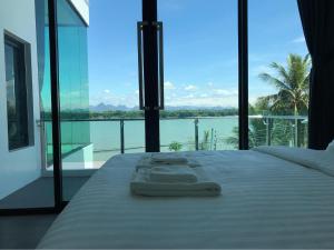 Dormitorio con cama y vistas al agua en Pool Villa Rimkhong Nakhorn Panom, 