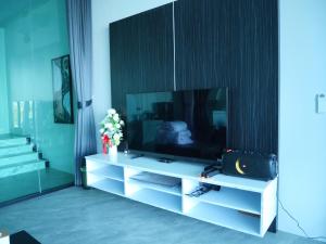 a living room with a television on a white entertainment center at Pool Villa Rimkhong Nakhorn Panom 