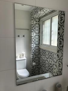 a bathroom mirror with a toilet and a window at Casa da Branca Gonta Colaço in Lisbon