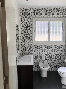 een badkamer met een wastafel, een toilet en een raam bij Casa da Branca Gonta Colaço in Lissabon