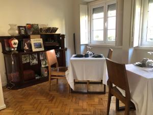 Casa da Branca Gonta Colaço في لشبونة: غرفة طعام مع طاولة وطاولتين وكراسي