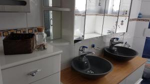 a bathroom with two sinks and mirrors on a counter at Appartement Lehnbach in Saas-Almagell