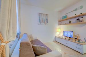 sala de estar con sofá y TV en Heart Of Riva - 100 Mt. From The Lake - Happy Rentals, en Riva del Garda