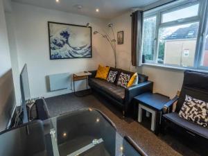 uma sala de estar com um sofá e uma televisão em Newly renovated ideally situated 2 bedroom flat em Bournemouth