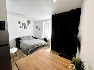 - une chambre avec un lit et un rideau noir dans l'établissement Appartements Climatisés Centre-ville / 10 personnes, à Besançon