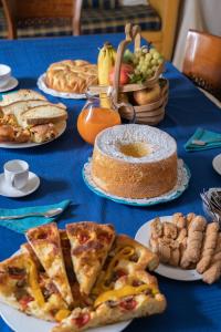 una mesa azul cubierta con platos de comida y pizza en B&B Iris en Laterza