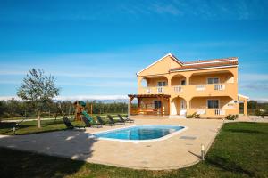una villa con piscina frente a una casa en Villa Levatinka ZadarVillas, en Prkos
