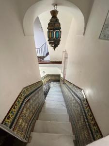 a stairway with a chandelier and a ceiling at Hostal Atenas in Seville