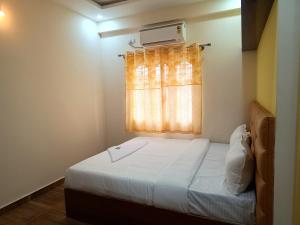 um pequeno quarto com uma cama e uma janela em STAYMAKER Karanji Paradise - Next to Liquor station em Bangalore