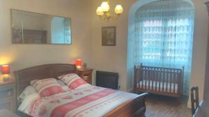 a bedroom with a bed with a mirror and a crib at A la Grenouille du Jura in Bellignat
