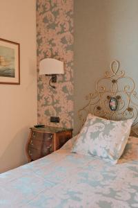 a bedroom with a bed and a dresser with a lamp at Rigat Park & Spa Hotel - Adults Recommended in Lloret de Mar