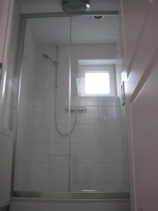 a bathroom with a shower with a glass door at Modern zomerhuis voor 4 personen in Wijk aan Zee