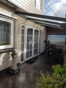 a house with a patio with sliding glass doors at Modern zomerhuis voor 4 personen in Wijk aan Zee