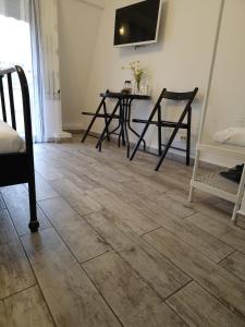 um quarto com piso em madeira, mesa e cadeiras em Stay in TimisoarAcom em Timisoara