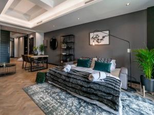 a bedroom with a large bed and a table at Luxury City Living - 1 Bedroom with balcony in Cape Town