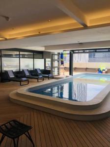 a large swimming pool in a building with chairs at Luxury City Living - 1 Bedroom with balcony in Cape Town