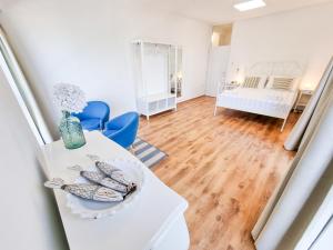 a living room with a white table and blue chairs at umag seafront seaview center apartment old town rentistra 3 in Umag