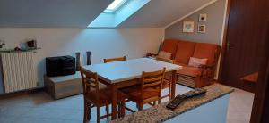 Una sala de estar con una mesa y sillas y un sofá. en Mansarda luminosa, en Turín