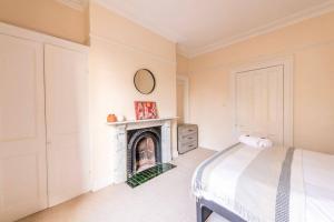 a bedroom with a bed and a fireplace at Modern Cambridge Park with FREE PARKING by Prescott Apartments in Bristol