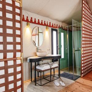 a bathroom with a sink and a mirror at Erg Chebbi Luxury Desert Camp in Merzouga