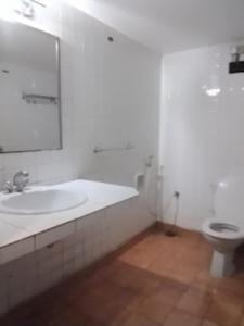 Baño blanco con lavabo y aseo en Hotel Indsurya, Dibrugarh en Dibrugarh