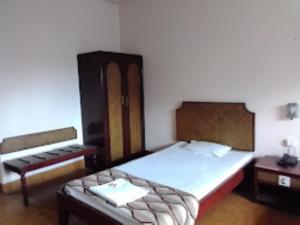 Habitación pequeña con cama y escritorio. en Hotel Indsurya, Dibrugarh en Dibrugarh